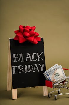 A chalkboard sign with Black Friday written on it and a small shopping cart with dollar bills, ideal for sales promotions.