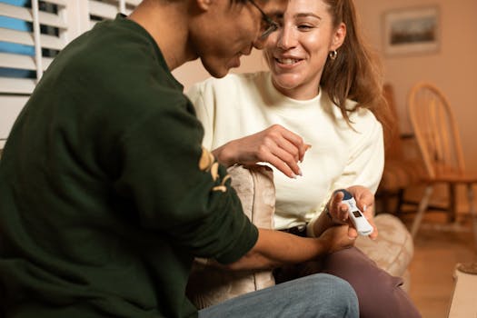 Happy couple celebrating positive pregnancy test at home together.