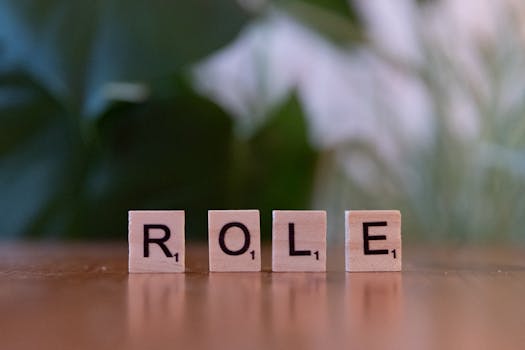 Close-up of Scrabble tiles spelling 'ROLE' on a wooden surface with a blurred background.