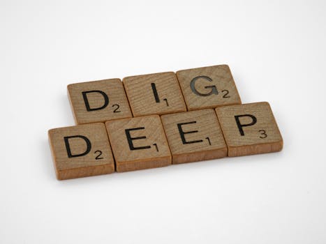Wooden Scrabble tiles spelling 'Dig Deep', perfect for concepts of inspiration and motivation.