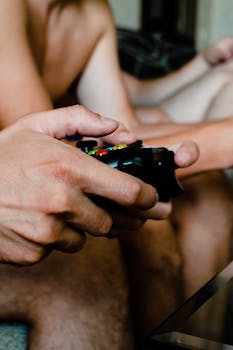 A close-up view of hands holding a gaming controller, symbolizing the immersive experience of gaming.