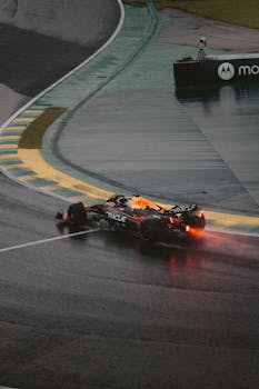 A racing car speeding on a wet track during rain, capturing motion and speed.