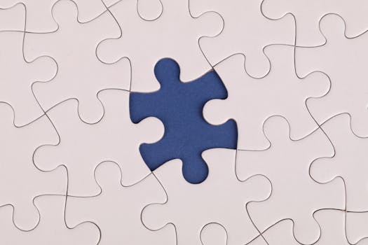 Close-up image of a white jigsaw puzzle with one piece missing, revealing a blue background.