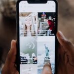 Close-up of a person using a smartphone to browse a social media app indoors.