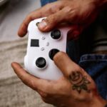 Close-up of hands holding a gaming controller, focused on gameplay.