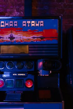 Close-up of vintage arcade machine lit by neon lights, featuring Cyrillic lettering.