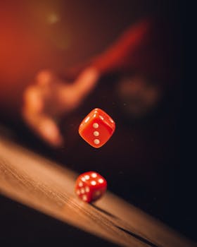 Close-up shot of red dice tumbling in motion against a blurred background, emphasizing chance and gamble.