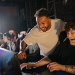 Gamers in a high-energy tournament setting enjoy competitive play with enthusiasm and teamwork.