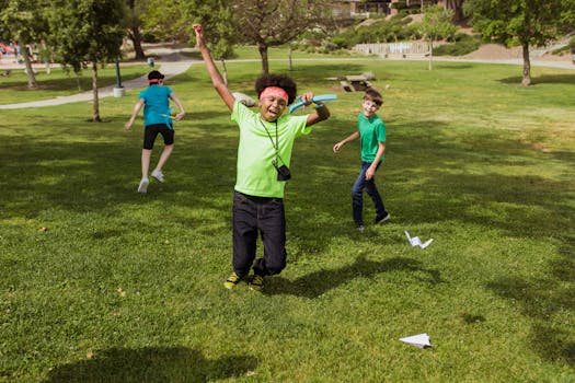 Kids having fun outdoors at summer camp playing with paper airplanes.