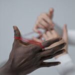 Two hands engage in a classic string game, focusing on connection.